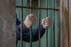 Mann hinter Gitterstäben