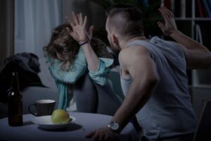 Mann schlägt Frau die sich mit Händen schützt