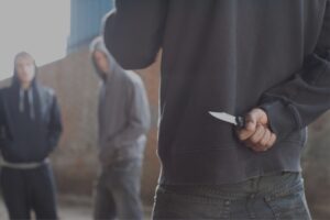 Mann versteckt Messer hinter dem Rücken